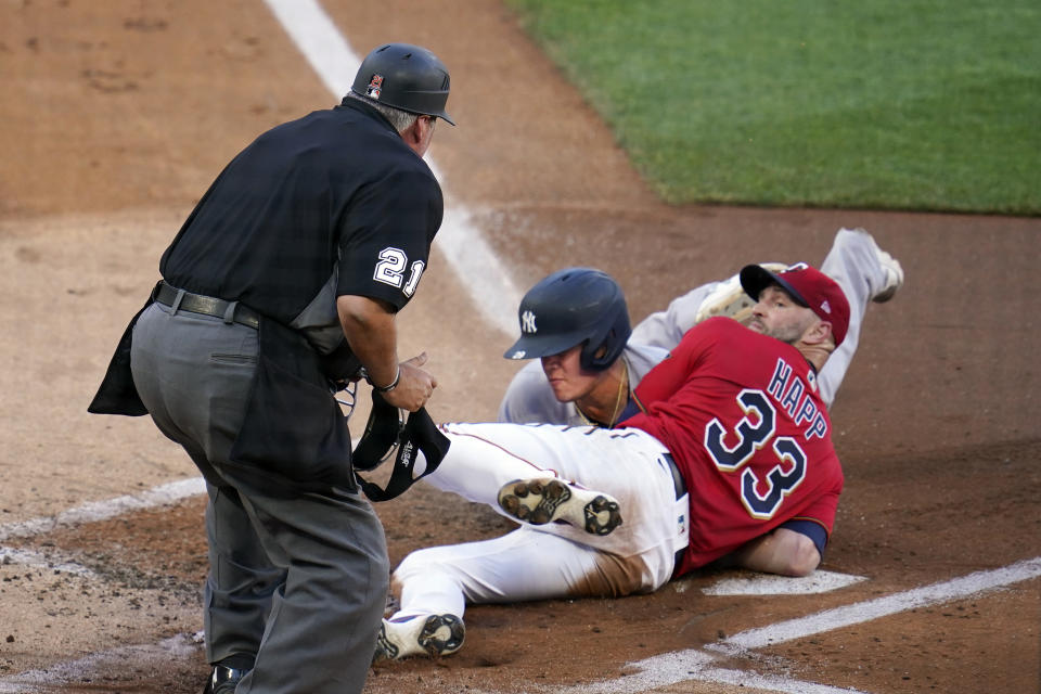 Minnesota Twins pitcher J.A. Happ (33) looks for the call by umpire Hunter Wendelstedt after tagging New York Yankees' Gio Urshela at the plate during the first inning of a baseball game Thursday, June 10, 2021, in Minneapolis. Urshela was initially called safe but on review the call was changed. (AP Photo/Jim Mone)