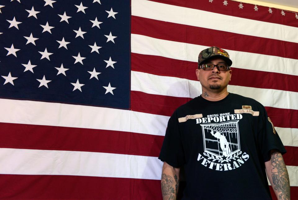 Ivan Ocon, who grew up in Las Cruces but was deported to Mexico for breaking the law, stands in front of a U.S. flag at his home in Juárez in 2019.