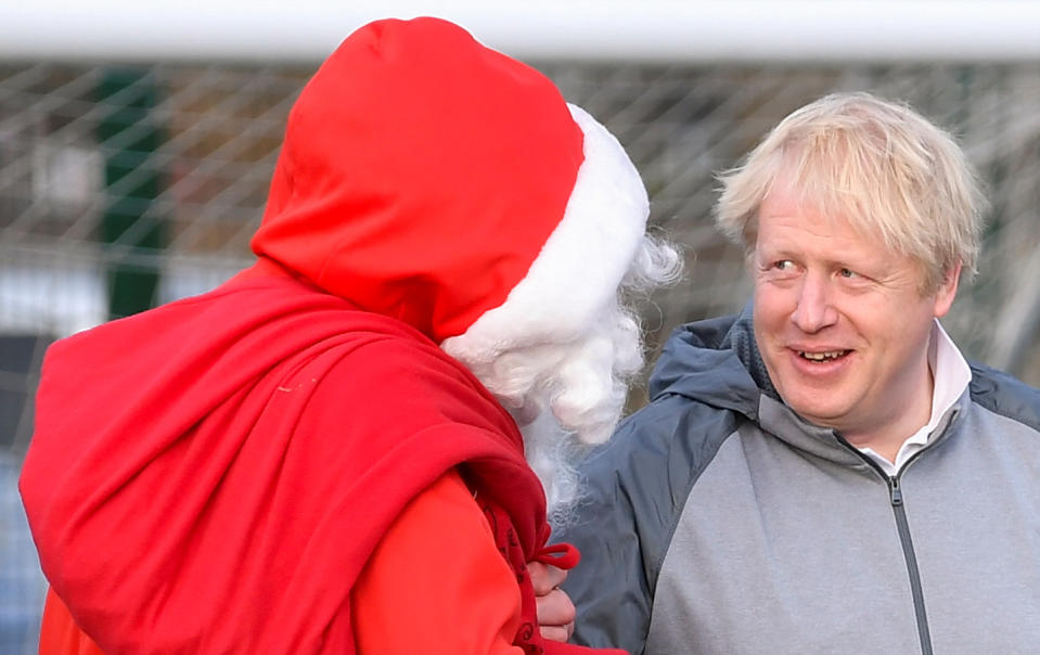 CHEADLE HULME, UNITED KINGDOM - DECEMBER 07: British Prime Minister Boris Johnson jokes with a man dressed as Father Christmas during the warm up before a girls' soccer match between Hazel Grove United JFC and Poynton Juniors on December 7, 2019 in Cheadle Hulme, United Kingdom. The Prime Minister is campaigning in the North West ahead general election on December 12. (Photo by Toby Melville - WPA Pool/Getty Images)