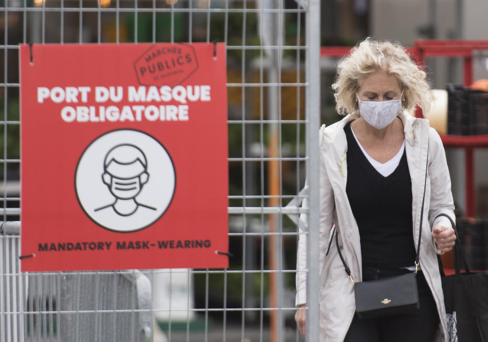 A woman wears a face mask as she walks through a market in Montreal, which has been Canada's epicentre throughout the COVID-19 pandemic. (Credit: The Canadian Press/Graham Hughes)