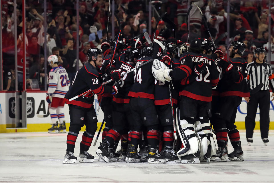 Carolina Hurricanes celebrate an overtime goal by Ian Cole against the New York Rangers in Game 1 of an NHL hockey Stanley Cup second-round playoff series in Raleigh, N.C., Wednesday, May 18, 2022. (AP Photo/Karl B DeBlaker)