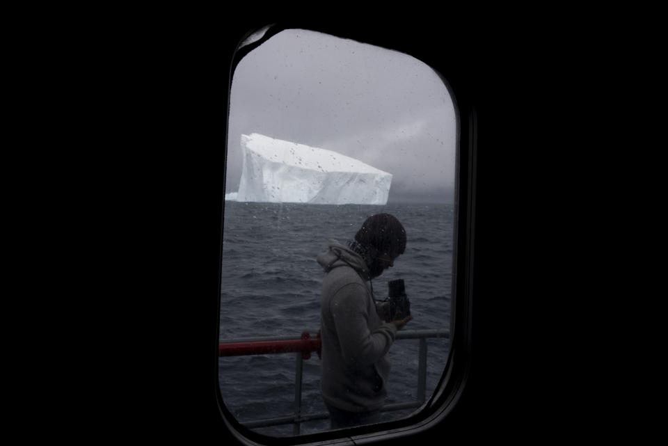 A member of the crew of Sea Shepherd Global's Allankay ship takes a photo of an iceberg in the Southern Ocean on March 5, 2023. The conservation group operates the Dutch-flagged vessel. (AP Photo/David Keyton)