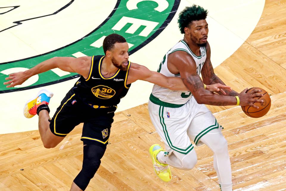 Golden State Warriors guard Stephen Curry (30) fouls Boston Celtics guard Marcus Smart (36) during the third quarter in game three of the 2022 NBA Finals at TD Garden.