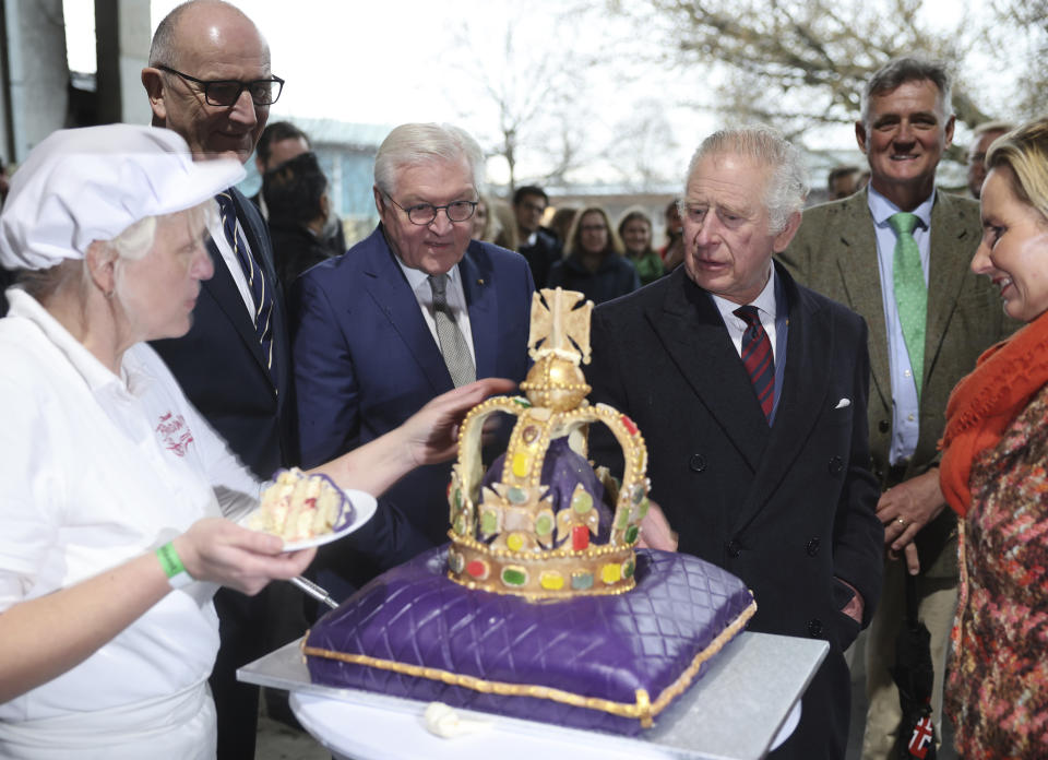 King Charles III of Great Britain, right, looks at a cake made especially for his visit in the Brodowin eco-village Germany, Thursday, March 30, 2023. A heavy thunderstorm with lightning and thunder upset the strict protocol of the royal visit to the in Brandenburg. (Jens Buettner/DPA via AP, Pool)