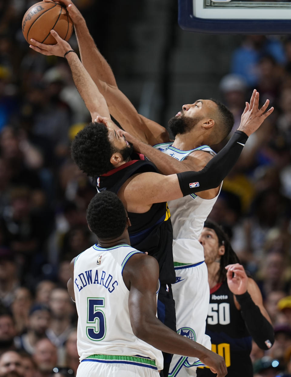 Minnesota Timberwolves center Rudy Gobert, back right, blocks a shot by Denver Nuggets guard Jamal Murray, back left, as Minnesota guard Anthony Edwards looks on in the second half of Game 7 of an NBA second-round playoff series Sunday, May 19, 2024, in Denver. (AP Photo/David Zalubowski)
