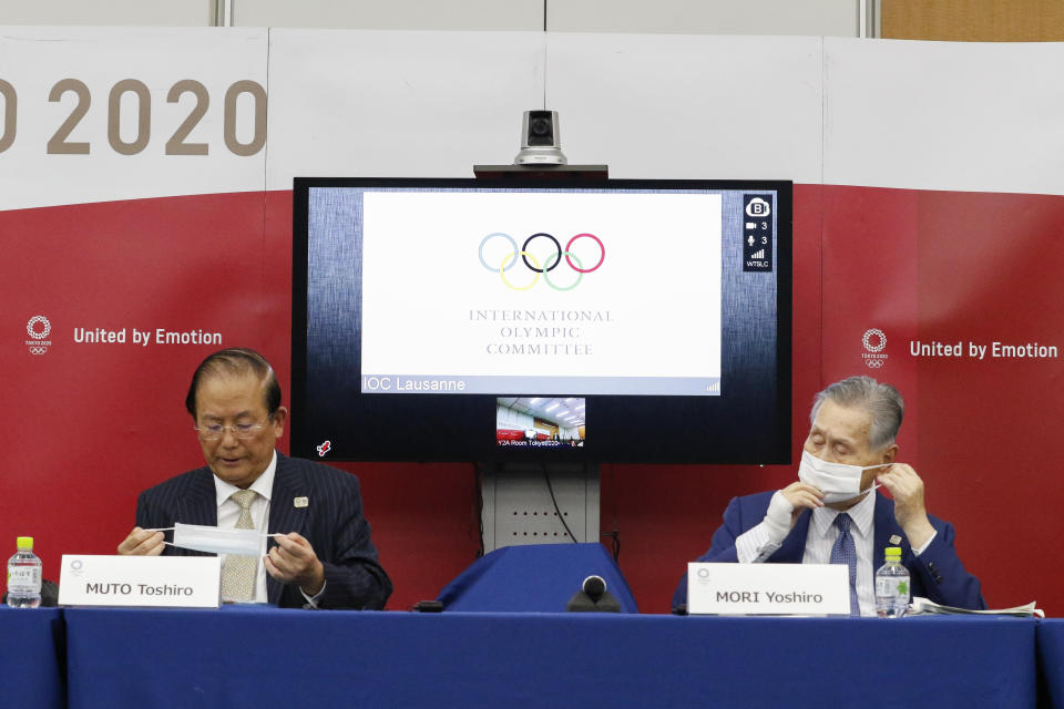 CEO of Tokyo 2020 Toshiro Muto and President of Tokyo 2020 Yoshiro Mori wear face masks as they leave a joint press conference between the International Olympic Committee (IOC) and Tokyo Organizing Committee of the Olympic and Paralympic Games (Tokyo 2020) Friday, Sept. 25, 2020, in Tokyo. (Rodrigo Reyes Marin/Pool Photo via AP)