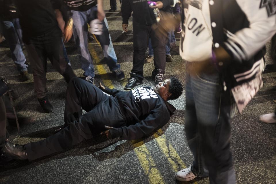 A protestor lays down in the street in front of the Ferguson Police Department during ongoing protests after the Justice Department released their report exposing corruption in the police department and court system of Ferguson, USA on March 12, 2015. Officials, including the Chief of Police, have been forced to resign after the release of the report.