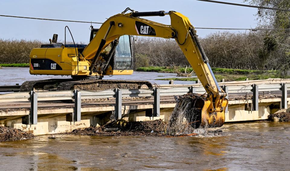 Crews work to unclog the Tule River Friday, March 17, 2023 at Road 192 just north of Avenue 168 and east of Woodville. Road closures are common in south Tulare County. Flood warnings have been issued for many areas.