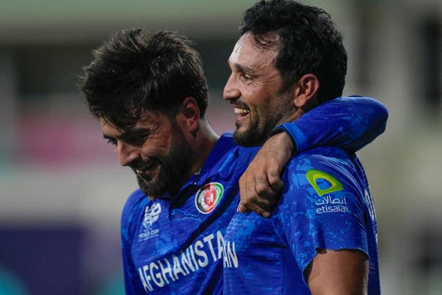 Rashid Khan, left, embraces team-mate Gulbadin Naib (Ricardo Mazalan/AP)