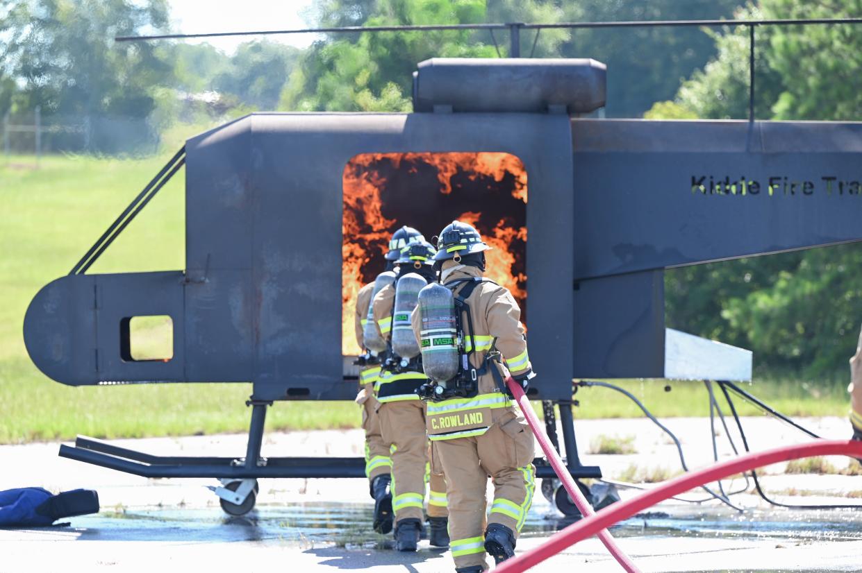 U.S. Air Force firefighters with the 908th Civil Engineer Squadron extinguish an internal aircraft fire during a joint interoperability training exercise, August 4, 2022, at Fort Benning, Georgia. This is the first time they were introduced to a helicopter trainer in preparation for the 908th Airlift Wing’s transition to the MH-139A Grey Wolf helicopter training mission.