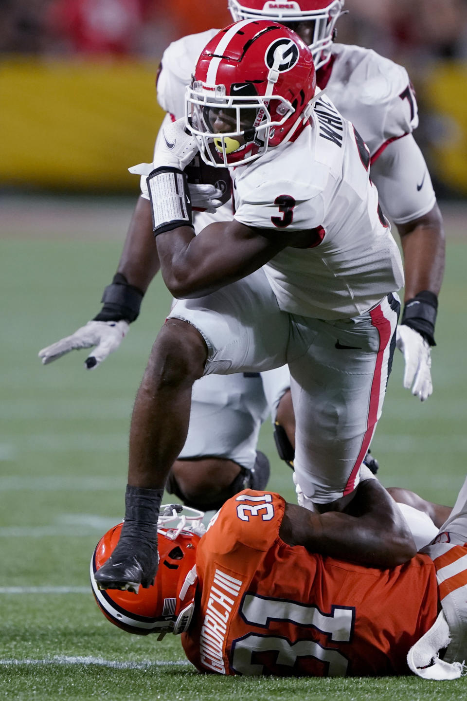 Georgia running back Zamir White runs over Clemson cornerback Mario Goodrich during the second half of an NCAA college football game Saturday, Sept. 4, 2021, in Charlotte, N.C. (AP Photo/Chris Carlson)