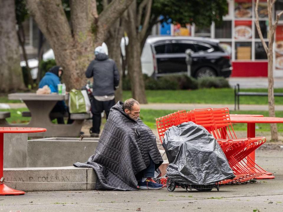 A man rests at Cesar Chavez Plaza on Thursday. Signs posted Wednesday state that a movie will be filmed in the area for three days starting Saturday.