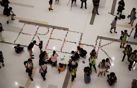 Anti-government protesters form a sign reading "Free HK" from folded paper birds during a demonstration at New Town Plaza shopping mall in Hong Kong