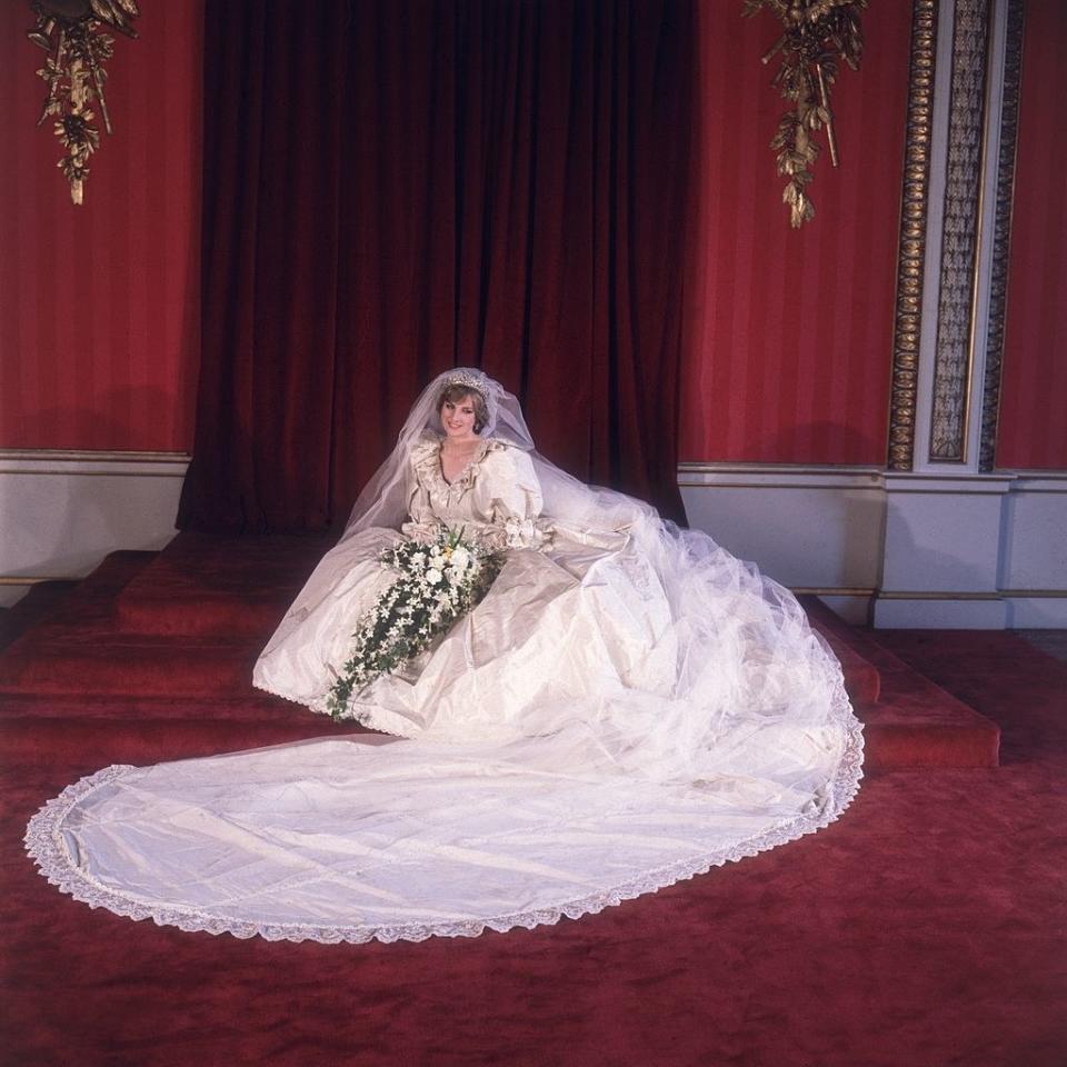 Princess Diana in a poufy white gown with big sleeves and a long train