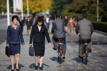 Two ladies pass two men on bicycles in the streets of central Wonsan, North Korea, October, 2016. Christian Petersen-Clausen/Handout via REUTERS