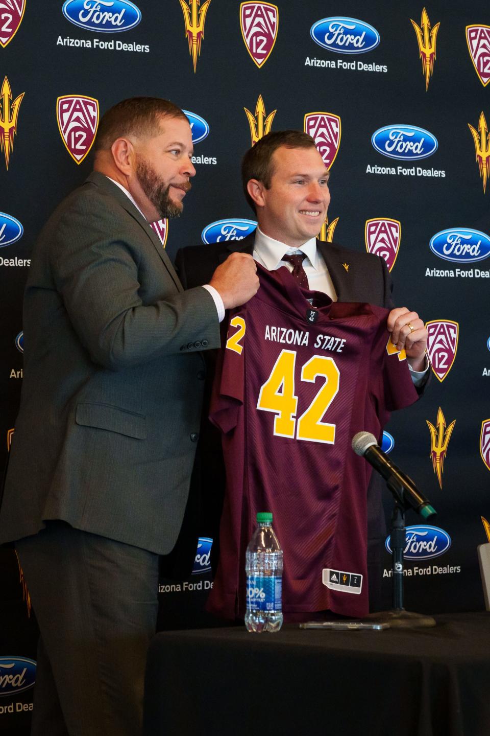 ASU's deputy athletic director, Jean Boyd (left) and newly appointed head football coach, Kenny Dillingham (right) hold up a jersey at a press conference on Nov. 27, 2022, in Tempe, AZ.