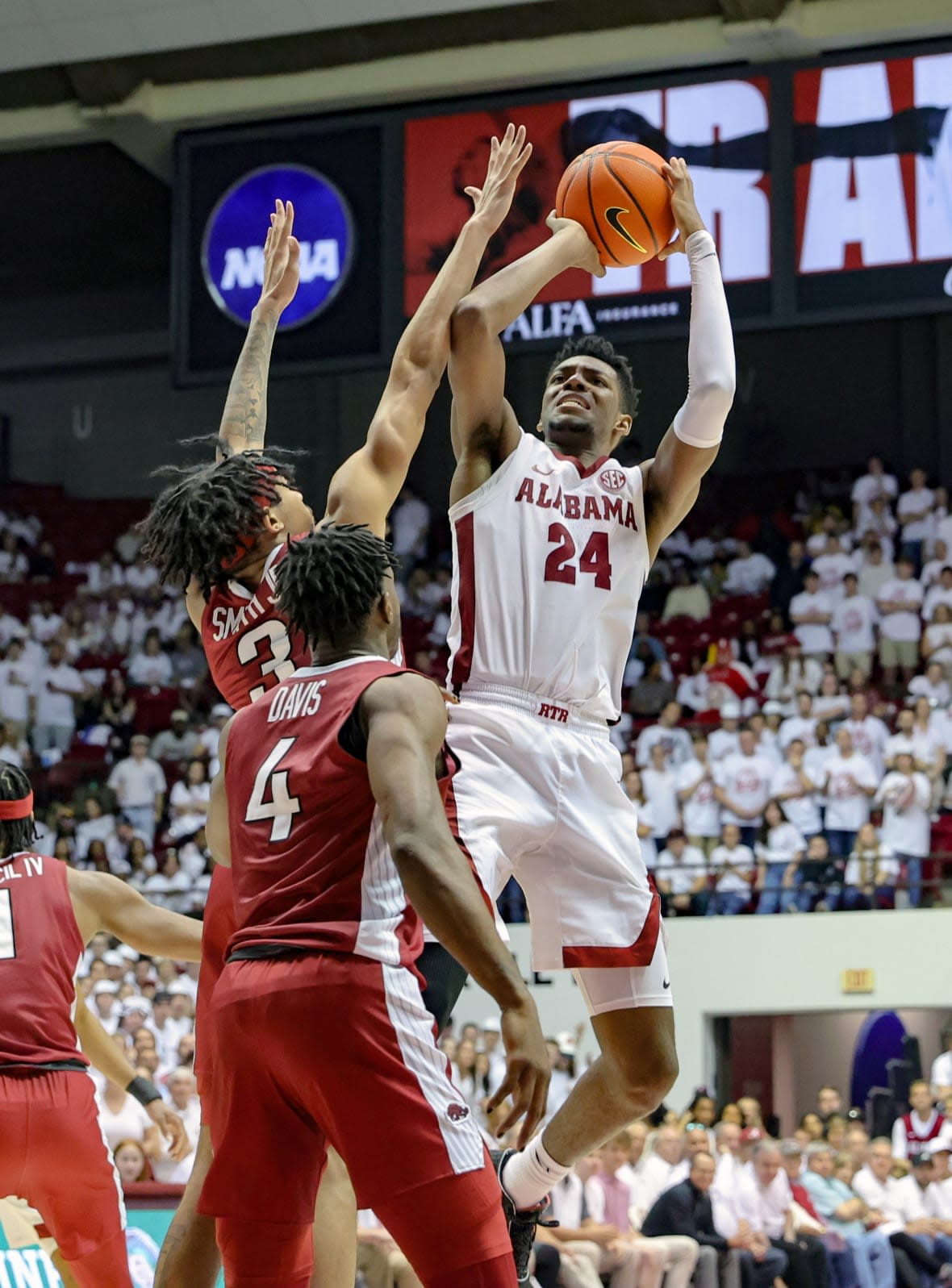 Brandon Miller #24 of the Alabama Crimson Tide shoots a second-half shot over Nick Smith Jr. #3 and Davonte Davis #4 of the Arkansas Razorbacks during the game at Coleman Coliseum on February 25, 2023 in Tuscaloosa, Alabama. (Photo by Brandon Sumrall/Getty Images)