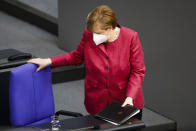 German Chancellor Angela Merkel takes her seat after her speech during a parliament session about a new law to battle the coronavirus pandemic at the parliament Bundestag in Berlin, Germany, Friday, April 16, 2021. (AP Photo/Markus Schreiber)