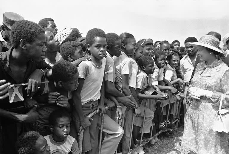 Escolares jamaicanos saludan jamaicano saludan a la reina Isabel II en el Monumento de los Héroes Nacionales en Kingston, Jamaica, el 14 de febrero de 1983, en el segundo día de la visita de la reina a la excolonia británica. 