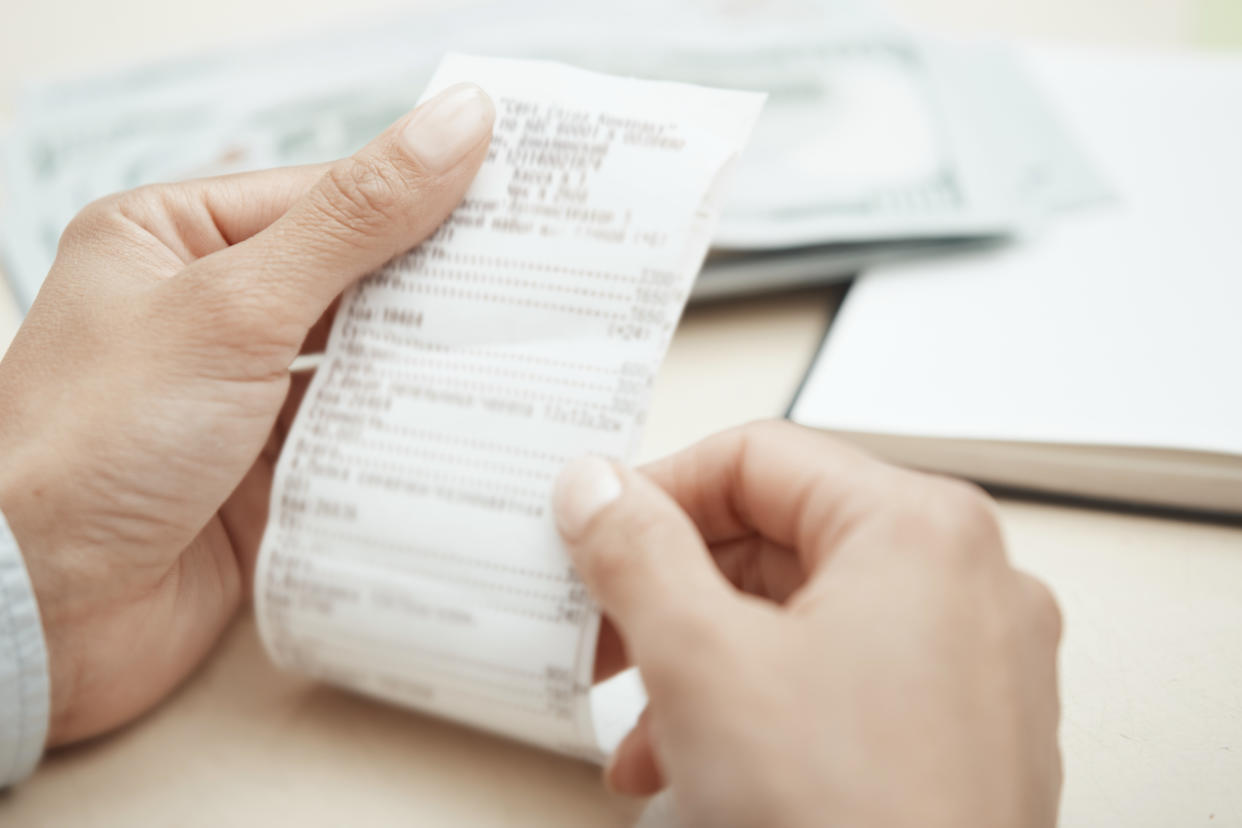 Hand of businesswoman checking invoice