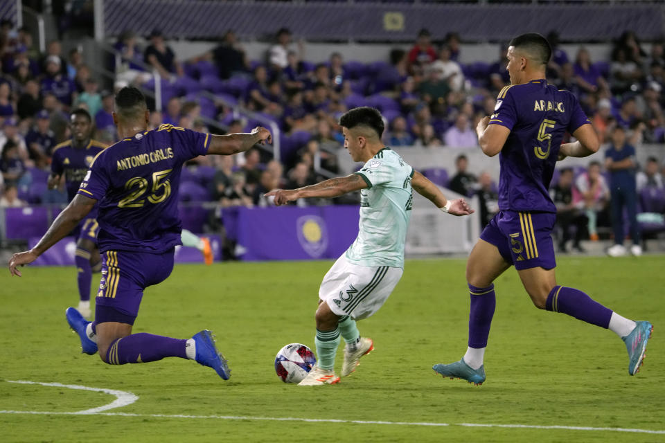 Atlanta United midfielder Thiago Almada, center, attempts a shot on goal as he gets between Orlando City defender Antonio Carlos (25) and midfielder Cesar Araujo (5) during the second half of an MLS soccer match, Saturday, May 27, 2023, in Orlando, Fla. (AP Photo/John Raoux)