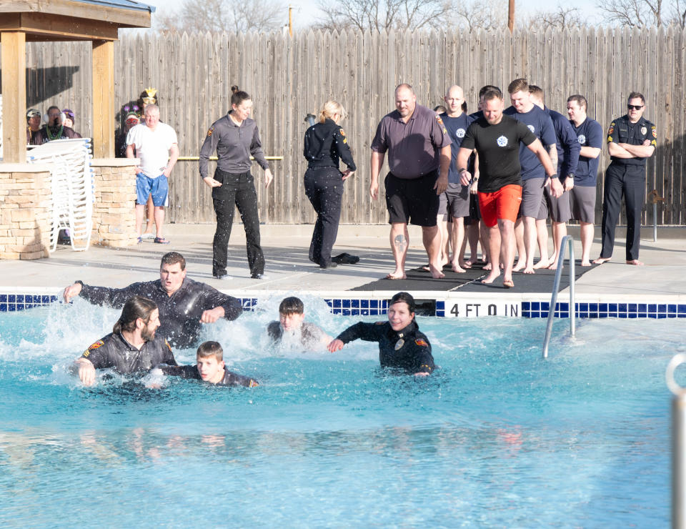 Members of the Amarillo Police Department work their way across the pool at the Polar Plunge Saturday morning at the Amarillo Town Club.