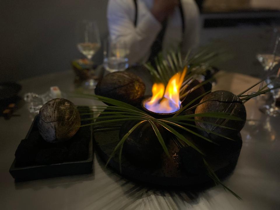 a fire surrounded by leaves in the middle of a table