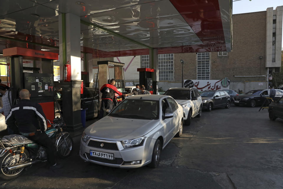 People fill their cars at a gas station in Tehran, Iran Wednesday, Oct. 27, 2021. Iran's President Ebrahim Raisi said Wednesday that a cyberattack which paralyzed every gas station in the Islamic Republic was designed to get "people angry by creating disorder and disruption." Long lines snaked around the pumps a day after the incident began as some stations began selling fuel again although at higher, unsubsidized prices. (AP Photo/Vahid Salemi)