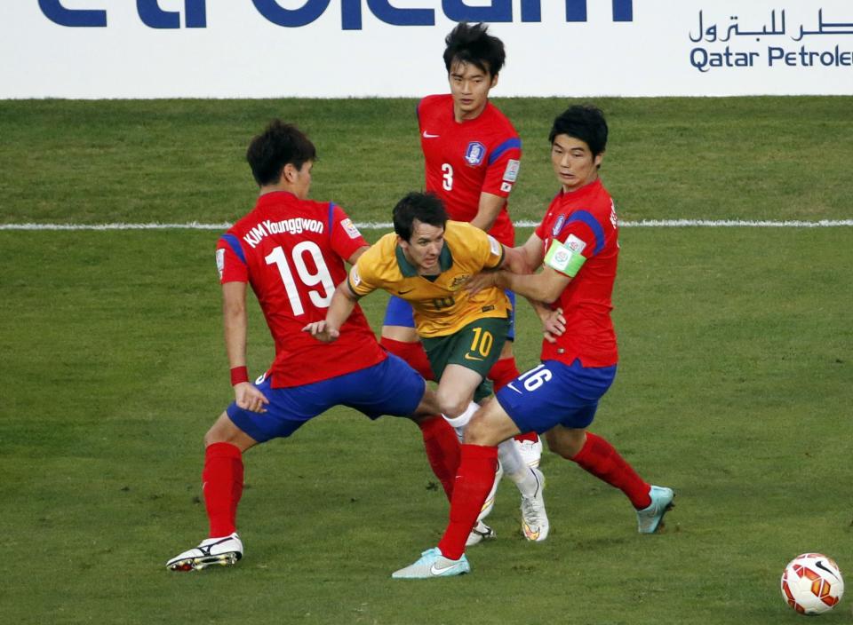 Australia's Robbie Kruse fights for the ball with South Korea's Kim Young-gwon, Kim Jin-su and Ki Sung-yueng during their Asian Cup final soccer match at the Stadium Australia in Sydney