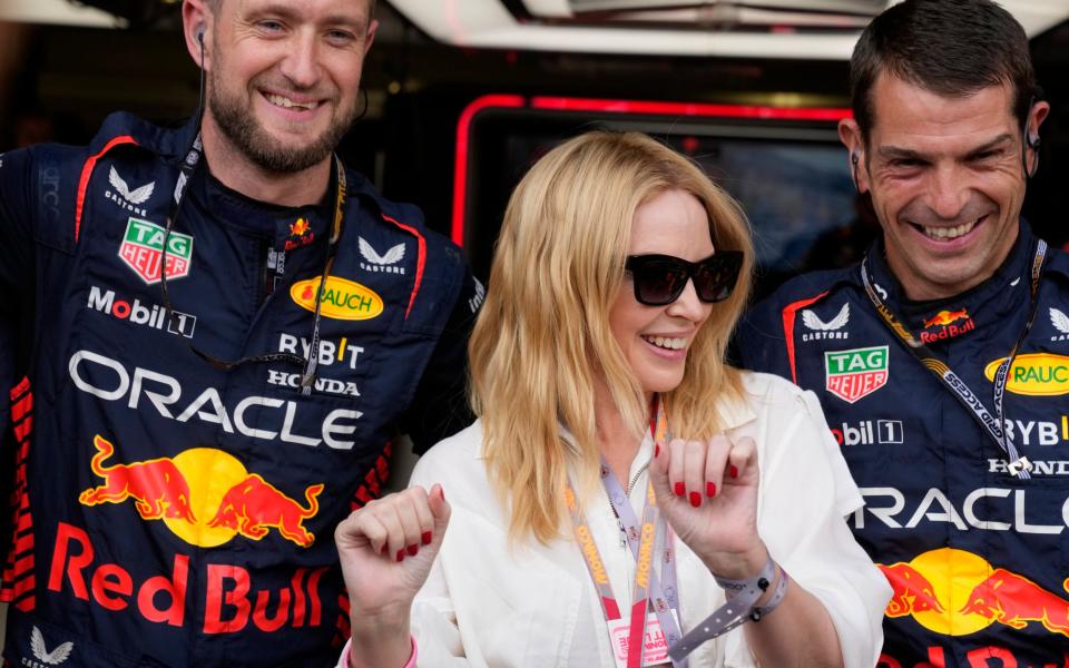 Australian singer Kylie Minogue poses with the Red Bull team in their garage prior to the Monaco Formula One Grand Prix, at the Monaco racetrack, in Monaco, Sunday, - AP/Luca Bruno