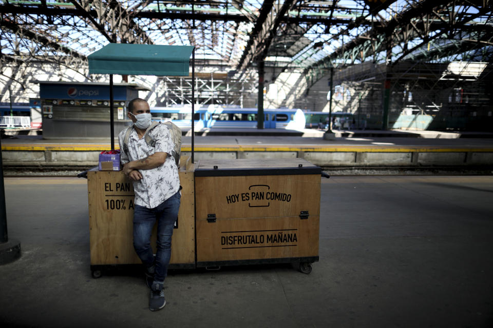 Un único vendedor ambulante se encuentra con su caja de bocadillos a la venta en una estación de tren vacía en Buenos Aires, Argentina, el viernes 20 de marzo de 2020. El gobierno argentino ha ordenado a los residentes que se pongan en cuarentena hasta el final del mes para ayudar a contener la propagación del nuevo coronavirus. (AP Foto / Natacha Pisarenko)