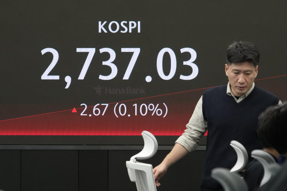 A currency trader passes by the screen showing the Korea Composite Stock Price Index (KOSPI) at the foreign exchange dealing room of the KEB Hana Bank headquarters in Seoul, South Korea, Wednesday, May 8, 2024. (AP Photo/Ahn Young-joon)