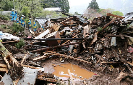 Rescue workers conduct search and rescue operations at a collapsed house at a landslide site caused by earthquakes in Minamiaso town, Kumamoto prefecture, southern Japan, in this photo taken by Kyodo April 17, 2016. Mandatory credit REUTERS/Kyodo
