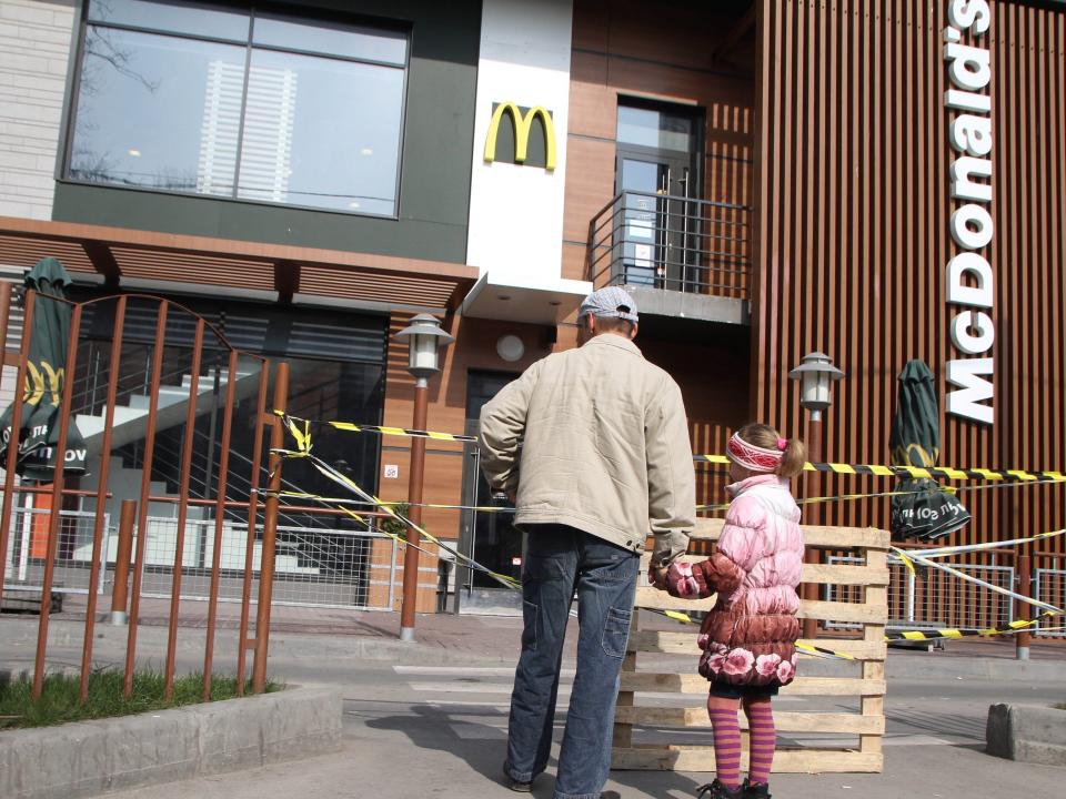 A man and a little girl look at a closed McDonald's in the Crimean capital Simferopol on April 4, 2014.