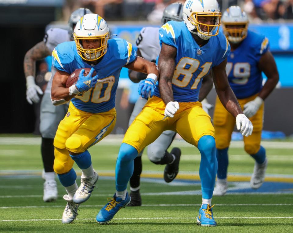 Chargers running back Austin Ekeler, left, carries the ball behind wide receiver Mike Williams.