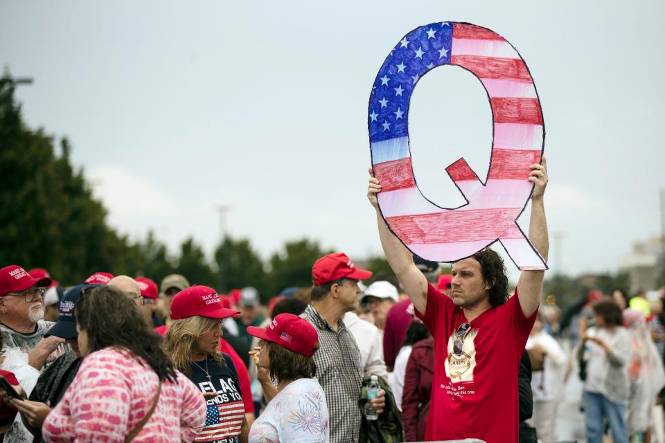 FILE - In this Aug. 2, 2018, file photo, a protesters holds a Q sign waits in line with others to enter a campaign rally with President Donald Trump in Wilkes-Barre, Pa. Candidates engaging with the QAnon conspiracy theory are running for seats in state legislatures this year, breathing more oxygen into a once-obscure conspiracy movement that has grown in prominence since adherents won Republican congressional primaries this year. (AP Photo/Matt Rourke, File) ORG XMIT: NYAG602