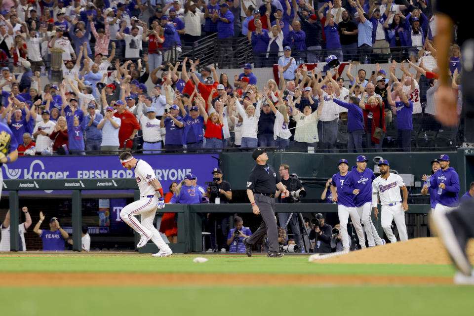 Texas Rangers' Jonah Heim celebrates after driving in the winning run against the Chicago Cubs during the 10th inning of a baseball game Thursday, March 28, 2024 in Arlington, Texas. (AP Photo/Gareth Patterson)