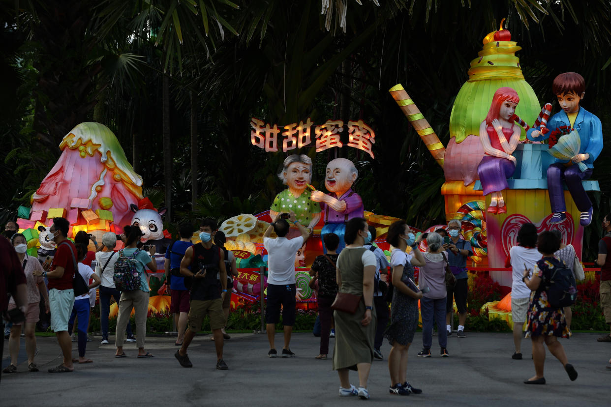 People in protective mask take photo with a lantern display during the River Hongbao festival, held as part of the Chinese New Year celebration at Gardens by the Bay on February 3, 2022 in Singapore. (Photo by Suhaimi Abdullah/NurPhoto via Getty Images)