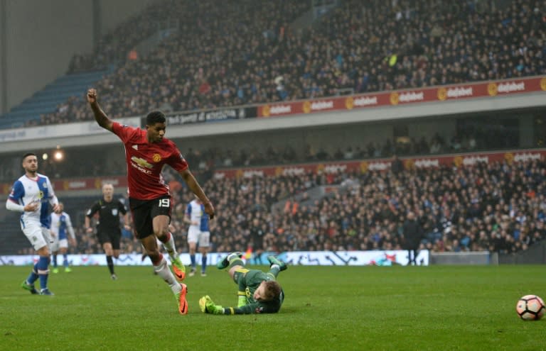 Manchester United's striker Marcus Rashford (L) scores past Blackburn Rovers' goalkeeper Jason Steele on February 19, 2017