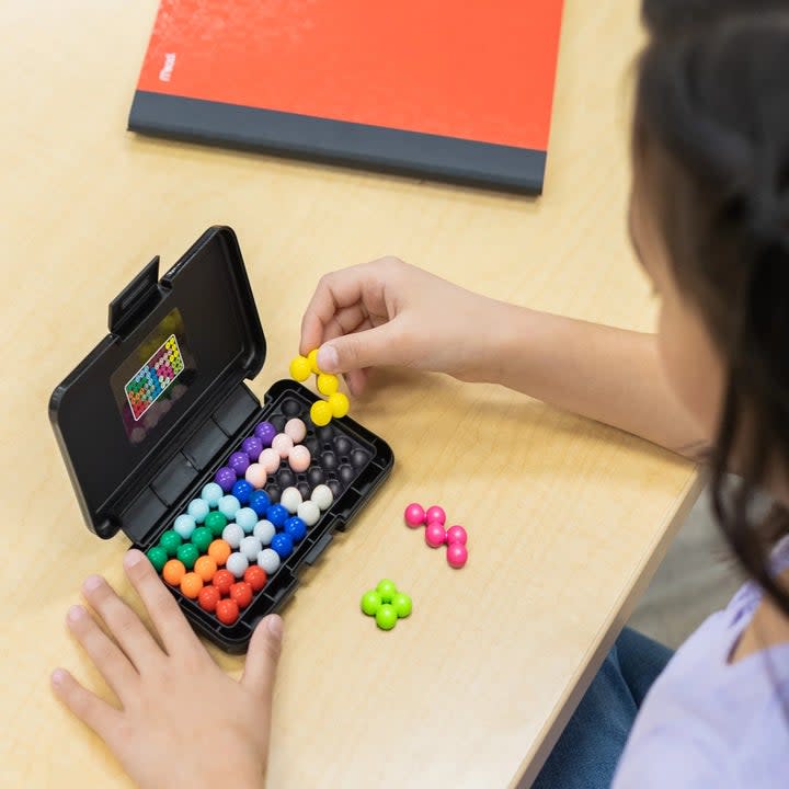 Child playing 2D version of Kanoodle game