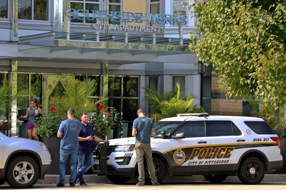 Investigators gather outside an apartment building on Pittsburgh's South Side where police say multiple people died and others were hospitalized Sunday, Sept. 22, 2019.