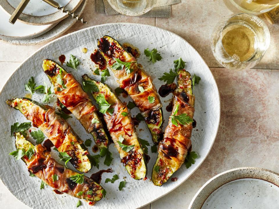 <p><b>Prosciutto-Wrapped Baked Zucchini with Balsamic Drizzle</b></p> <p>Wrapped in salty prosciutto and roasted until tender, this quick-and-easy zucchini recipe makes a light summer main dish. You can choose your own adventure when it comes to this recipe—prepare it in the oven, or fire up your grill for an extra layer of charred, smoky flavor. Don’t forget to drizzle with balsamic glaze for a lightly sweet finish.</p><p><a href="https://www.foodandwine.com/recipes/prosciutto-wrapped-baked-zucchini-balsamic-drizzle" rel="nofollow noopener" target="_blank" data-ylk="slk:GO TO RECIPE;elm:context_link;itc:0;sec:content-canvas" class="link ">GO TO RECIPE</a></p>