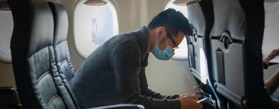 man on plane wearing a mask