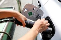 An employee fuels hydrogen to a Hyundai Motor's Nexo hydrogen car at a hydrogen station in Seoul