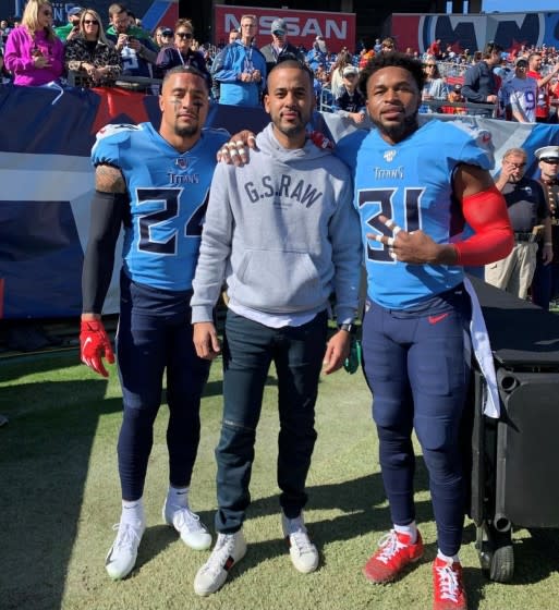 David Mulugheta is flanked by Titans players Kenny Vaccaro, left, and Kevin Byard. .