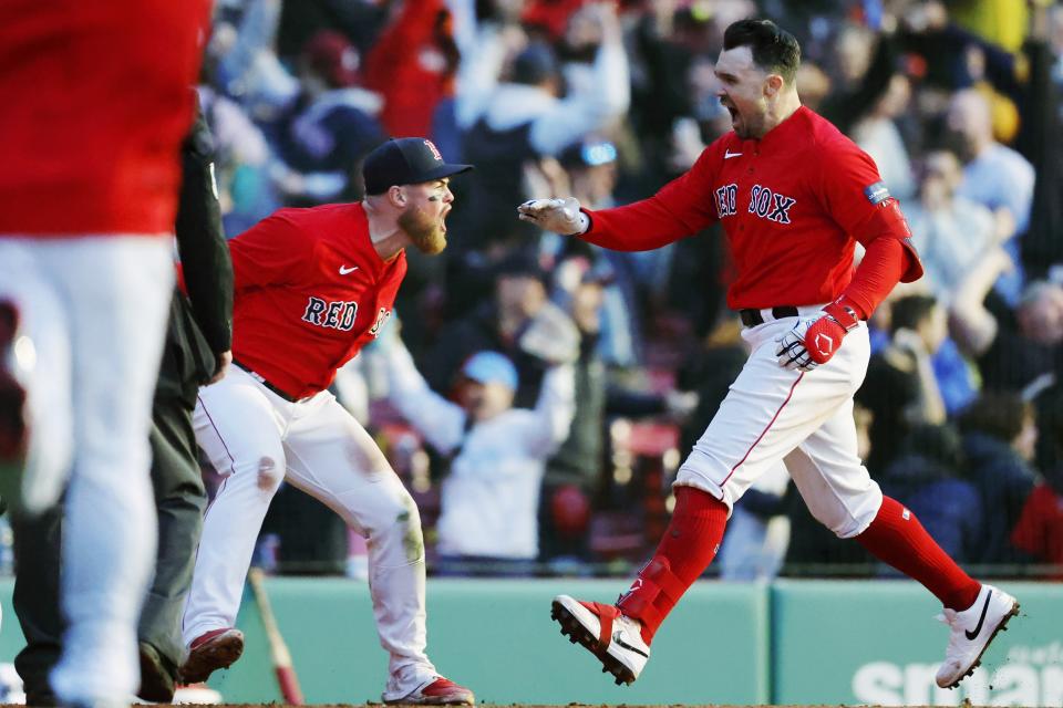 Boston Red Sox's Christian Arroyo, left, greets Adam Duvalll, right, at home plate after Duvall's two-run, walk-off home run in the ninth inning of a baseball game against the Baltimore Orioles, Saturday, April 1, 2023, in Boston. (AP Photo/Michael Dwyer)