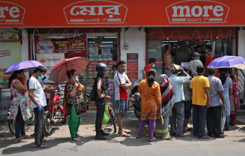 People queue to buy grocery items outside a store before the start of lockdown by West Bengal state government, to limit the spreading of coronavirus disease (COVID-19), in Kolkata