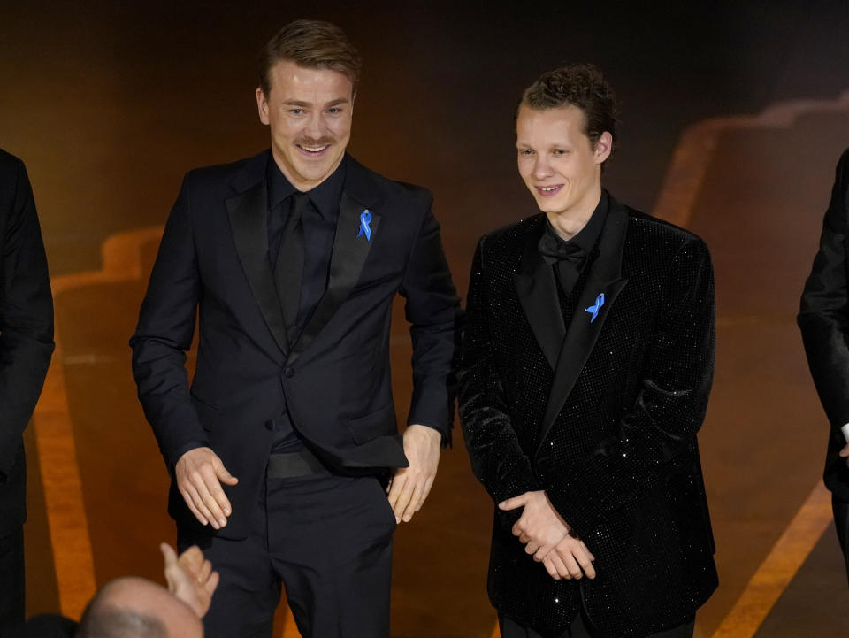 Albrecht Abraham Schuch, left, and Felix Kammerer appear onstage as "All Quiet on the Western Front" from Germany wins for best international feature film at the Oscars on Sunday, March 12, 2023, at the Dolby Theatre in Los Angeles. (AP Photo/Chris Pizzello)