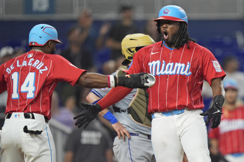 Miami Marlins' Josh Bell, left, celebrates with Bryan De La Cruz (14) after Bell hit a home run scoring De La Cruz and Jazz Chisholm Jr., during the ninth inning of a baseball game against the New York Mets, Saturday, May 18, 2024, in Miami. (AP Photo/Wilfredo Lee)