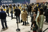 People queue to get vaccinated against COVID-19 on the first day of a new vaccination center in Lisbon, Wednesday, Dec. 1, 2021. Long lines formed at the Portuguese capital's largest vaccination center to date as authorities there tried to encourage the 2% of the population who are not vaccinated yet, Europe's lowest rate, and to speed up the administration of booster shots. Despite its excellent vaccination record, cases have been rising non-stop over the past two months, although hospitalizations are far away from levels seen in previous surges. (AP Photo/Armando Franca)